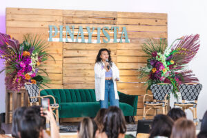 Gina Mariko Rosales speaking at Pinayista summit in front of logo